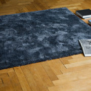 Schwarzblauer Teppich auf Holzparkett